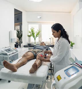 Physiotherapist treating patient's knee on treatment bed