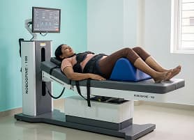 Patient on decompression table with harness during spinal traction treatment