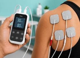 Physiotherapist placing TENS electrodes on a patient's knee at Vyana Ahmedabad