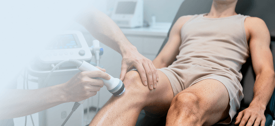 Physiotherapist using advanced therapy equipment on patient's knee