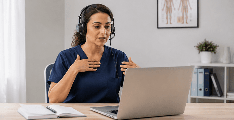 Physiotherapist in navy scrubs wearing a headset, guiding a patient through movement during a live online session