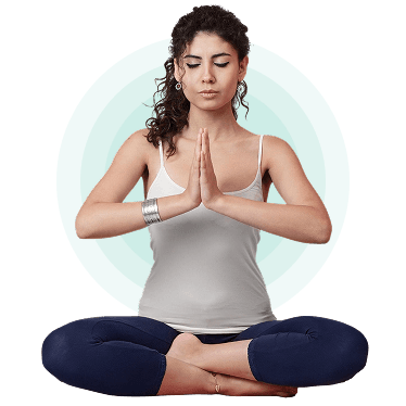 Woman seated in lotus pose with hands in prayer, practising yoga at home