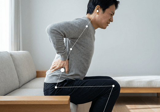 Man bending forward holding his lower back in pain