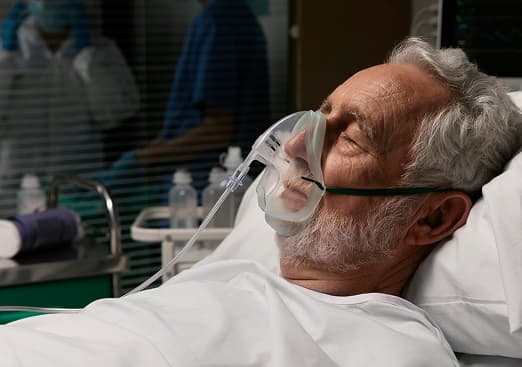 Patient undergoing supervised respiratory rehabilitation with physiotherapist